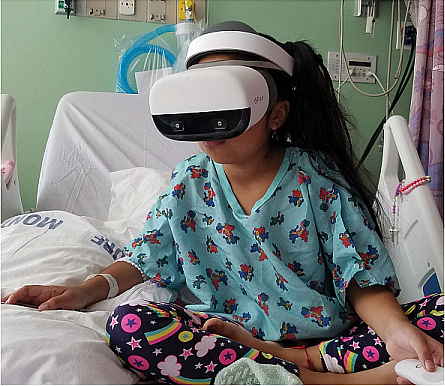 Child in hospital bed using VR headset