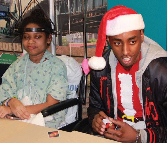Anthony Mason Jr. visits with a young CHAM patient during the holidays.